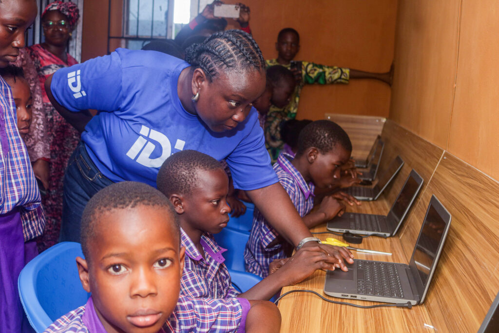 An IDI representative leading an interactive demonstration session with the staff and pupils of African Church Central School, Abalabi.